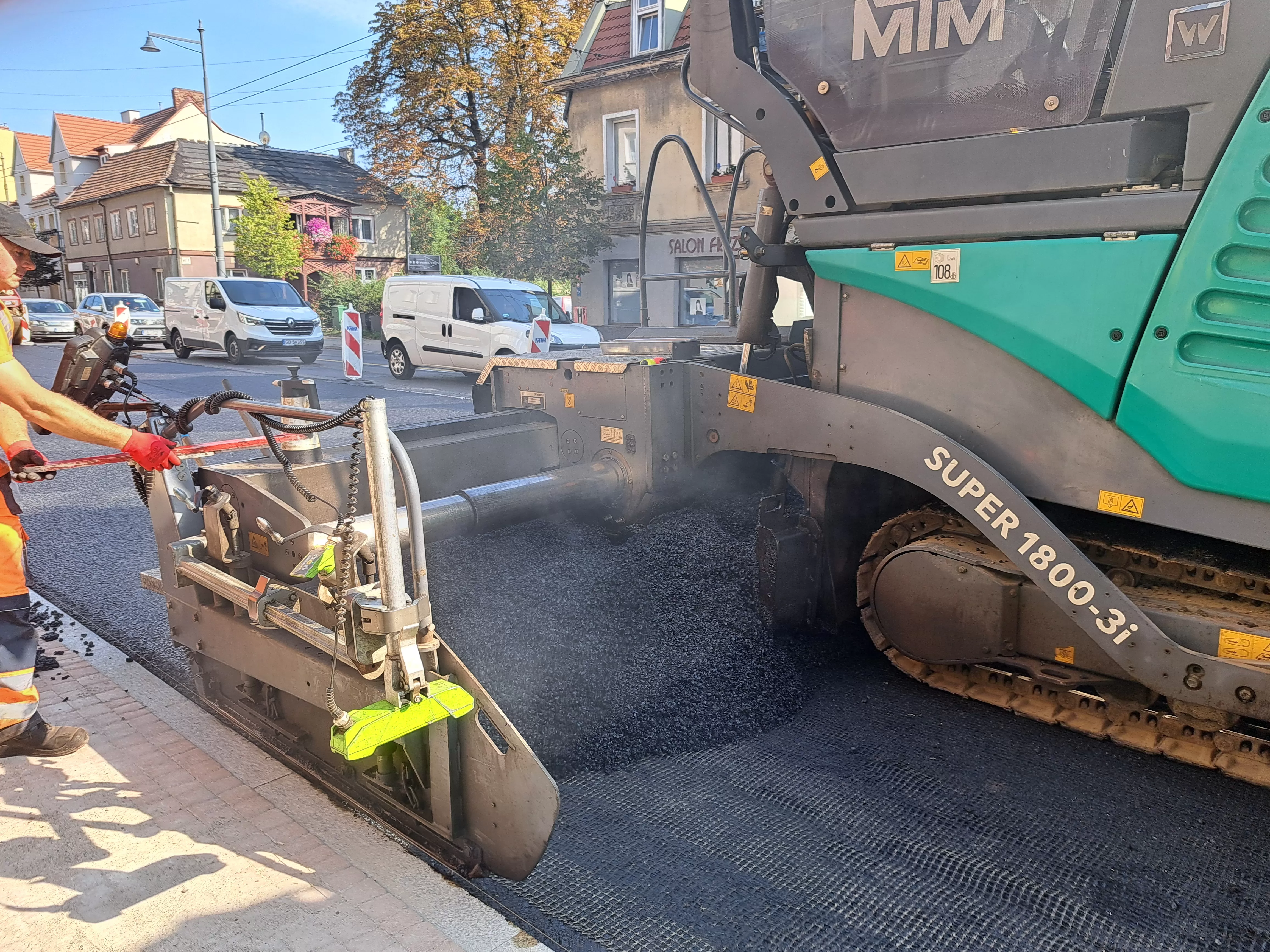 Aleja Niepodległości – układanie masy bitumicznej na remontowanym odcinku